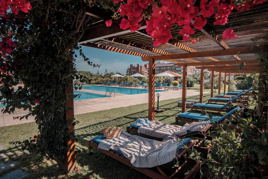 Piscina con reposeras y bugambilias en Il Belvedere