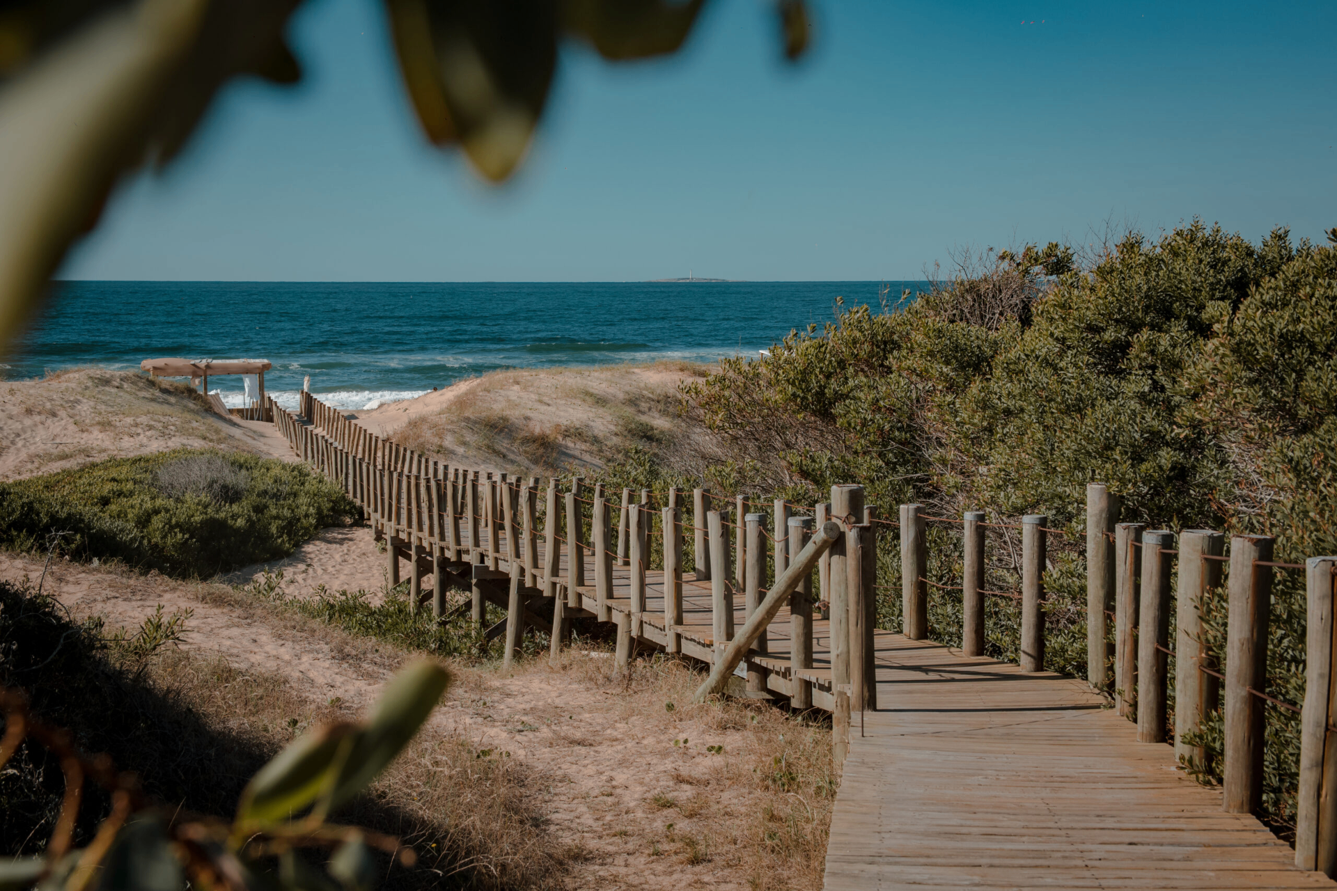 Pasarela de madera entre las dunas hacia el mar en Punta del Este