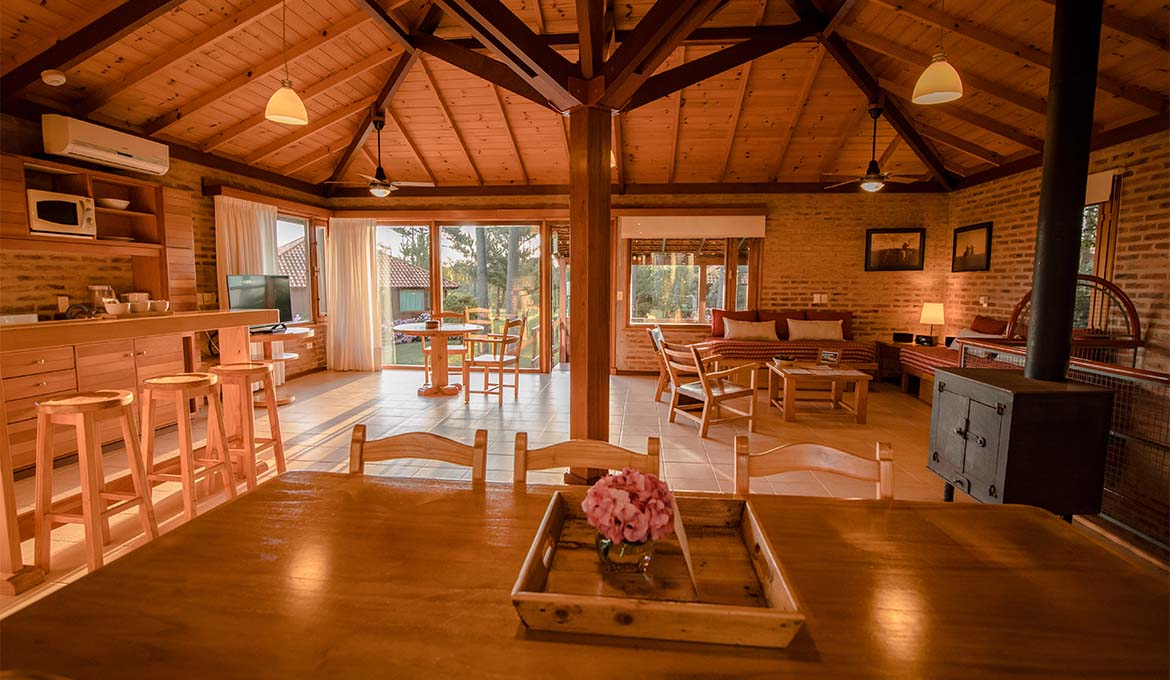 Living comedor de la cabaña con techo de madera y estufa a leña